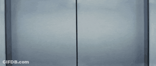 Woman In Glasses Peeking Out Of Door GIF