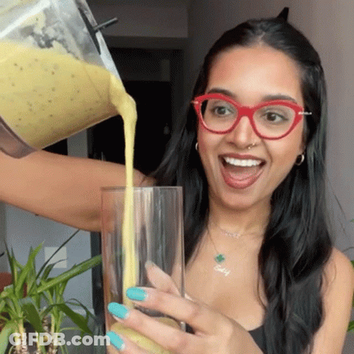 Woman In Glasses Pouring Smoothie Into Glass GIF