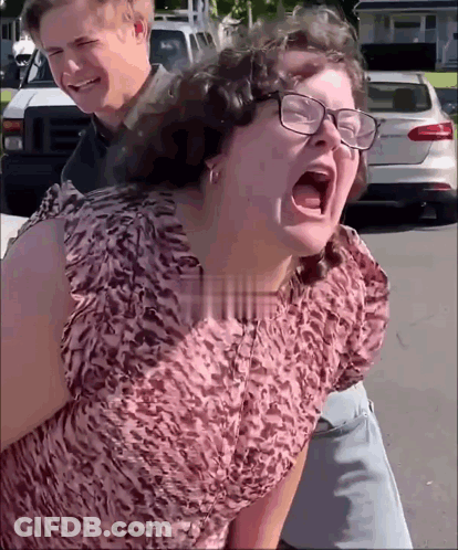 Woman In Glasses Screaming Man Holds Her Back GIF