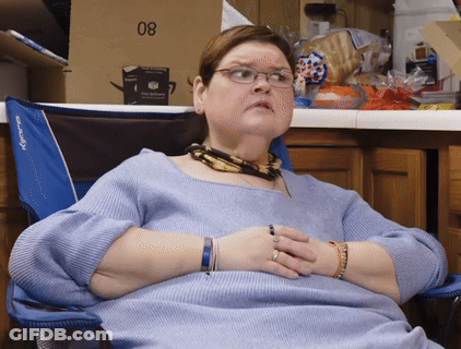 Woman In Glasses Sits In Blue Chair With Box 08 GIF