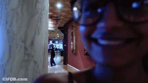 Woman In Glasses Smiling At Exit Sign GIF