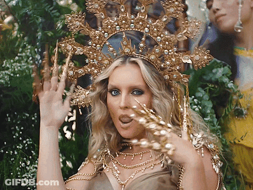 Woman In Gold Crown And Necklaces Making A Face GIF
