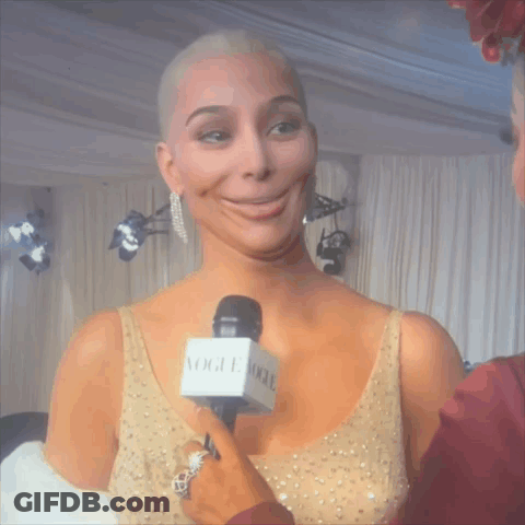 Woman In Gold Dress Being Interviewed GIF