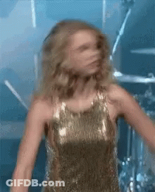 Woman In Gold Dress Dancing On Stage GIF