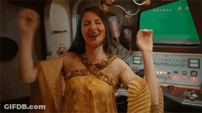 Woman In Gold Dress Raising Arms GIF