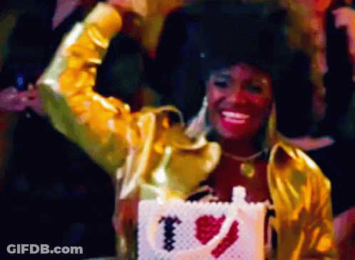 Woman In Gold Jacket Holding Purse Saying I Love You GIF