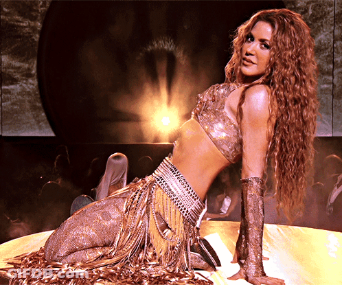 Woman In Gold Outfit Kneeling On Stage GIF