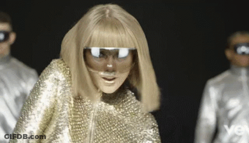 Woman In Gold Outfit With Mask And Sunglasses GIF