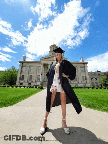 Woman In Graduation Cap And Gown In Front Of Building GIF