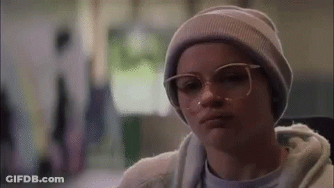 Woman In Gray Hoodie And White Sweatpants Under Gypsy Vinyl Sign GIF