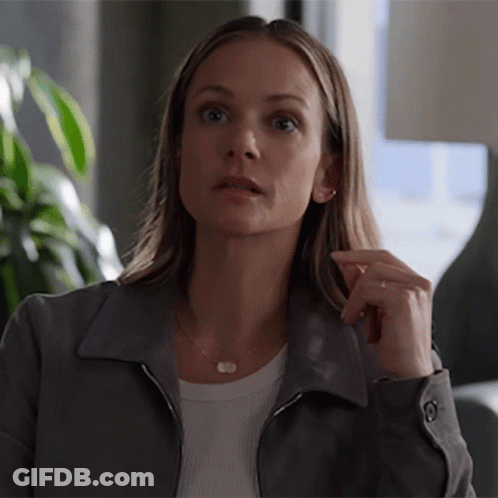 Woman In Gray Jacket And White Shirt Looks Surprised GIF