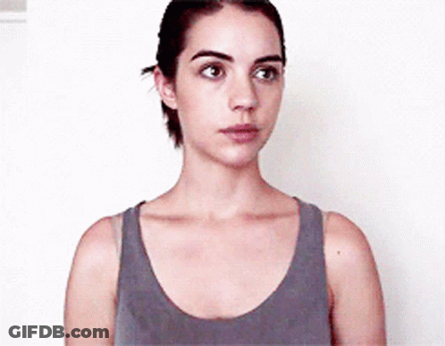 Woman In Gray Tank Top Looks At Camera GIF