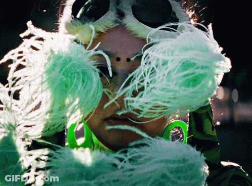 Woman In Green And White Feathered Mask GIF