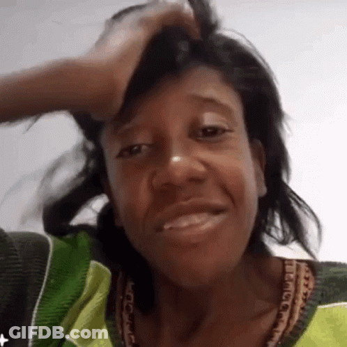 Woman In Green And Yellow Smiling Holding Head GIF