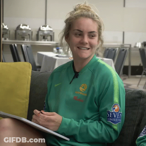 Woman In Green Australia Jacket On Couch GIF