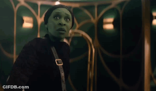 Woman In Green Costume Next To Woman In White Dress GIF