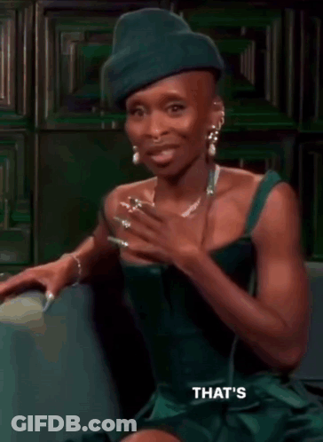 Woman In Green Dress And Green Hat On Couch GIF