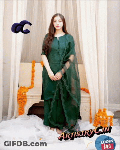 Woman In Green Dress In Front Of Couch With Flowers GIF