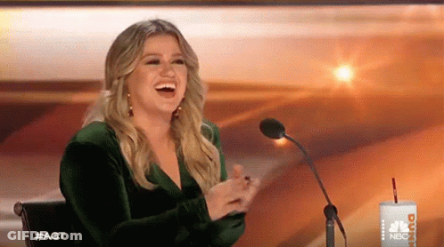 Woman In Green Dress Laughing At Microphone GIF