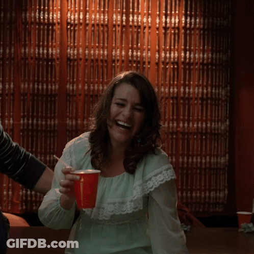 Woman In Green Dress Laughing With Red Cup GIF