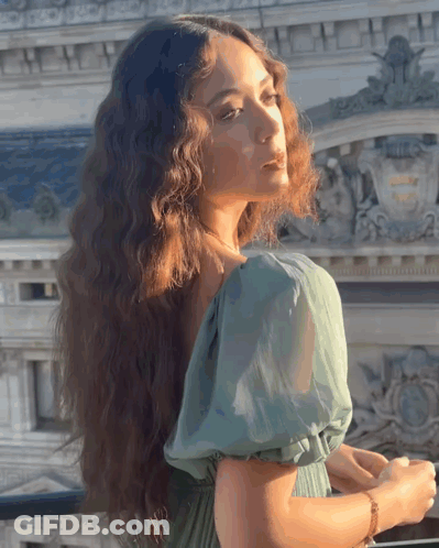 Woman In Green Dress Near Building With A Sign GIF
