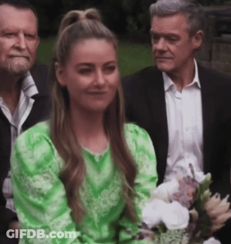 Woman In Green Dress Smiling With Bouquet GIF