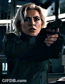 Woman In Green Jacket Hand To Ear Funny Face GIF