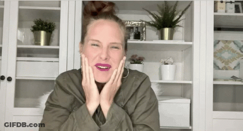 Woman In Green Jacket Making Funny Face With Hands On Face GIF