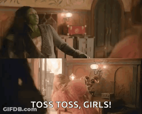 Woman In Green Mask Saying Toss Toss Girls Beside Pink Dress Girl GIF