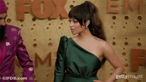 Woman In Green One-Shoulder Dress With Fox Sign GIF