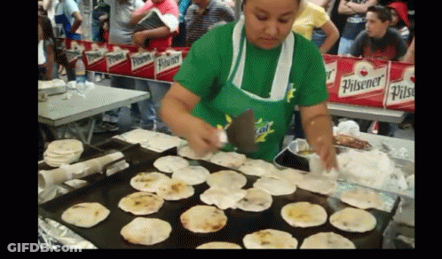 Woman In Green Pilsener Shirt Cooking GIF