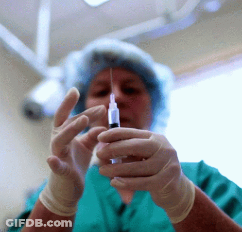 Woman In Green Scrubs Holding Syringe GIF