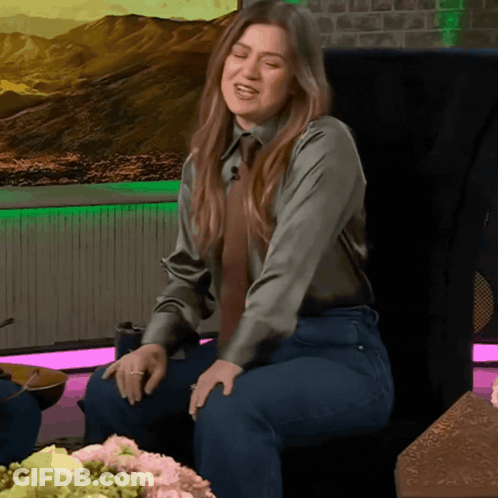 Woman In Green Shirt And Tie Sitting GIF