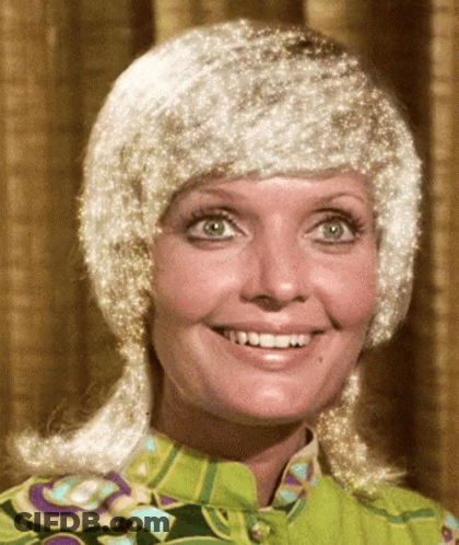Woman In Green Shirt And White Wig Smiles GIF