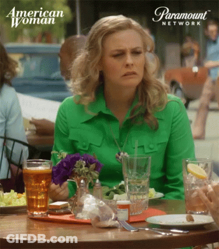 Woman In Green Shirt At Table GIF