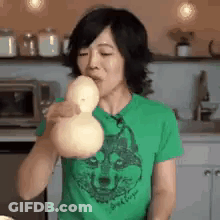 Woman In Green Shirt Blowing Balloon GIF