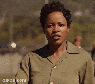 Woman In Green Shirt Making Funny Face And Waving GIF