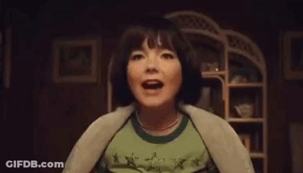 Woman In Green Shirt Screaming In Dark Room GIF