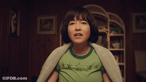 Woman In Green Shirt Screaming In Dark Room GIF