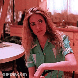 Woman In Green Shirt Sitting At Round Table GIF
