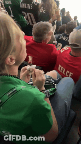 Woman In Green Shirt Sitting Next To Man In Red Kelce Shirt GIF