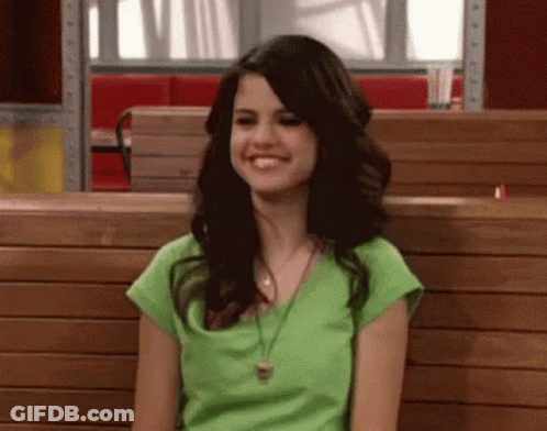Woman In Green Shirt Smiling On Wooden Bench In Restaurant GIF