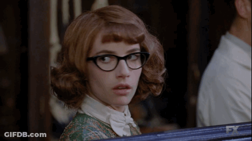 Woman In Green Shirt Standing Before FX Sign GIF