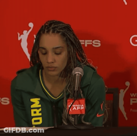 Woman In Green Storm Jersey In Front Of Red Wall GIF