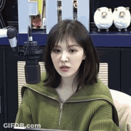 Woman In Green Sweater At Microphone GIF