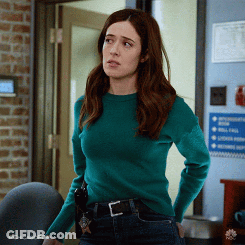 Woman In Green Sweater Standing In Front Of Door GIF