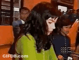 Woman In Green Sweater Talking On Phone While Man Looks On GIF