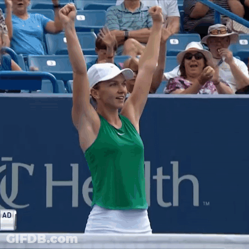 Woman In Green Tank Top And White Skirt Arms Raised GIF