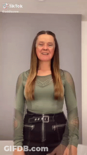 Woman In Green Top And Black Skirt Smiling GIF