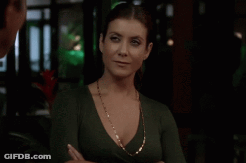 Woman In Green Top And Gold Necklace With Arms Crossed GIF